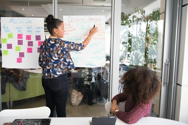 two women having a meeting inside glass panel office