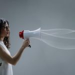 wavy haired woman holding a megaphone