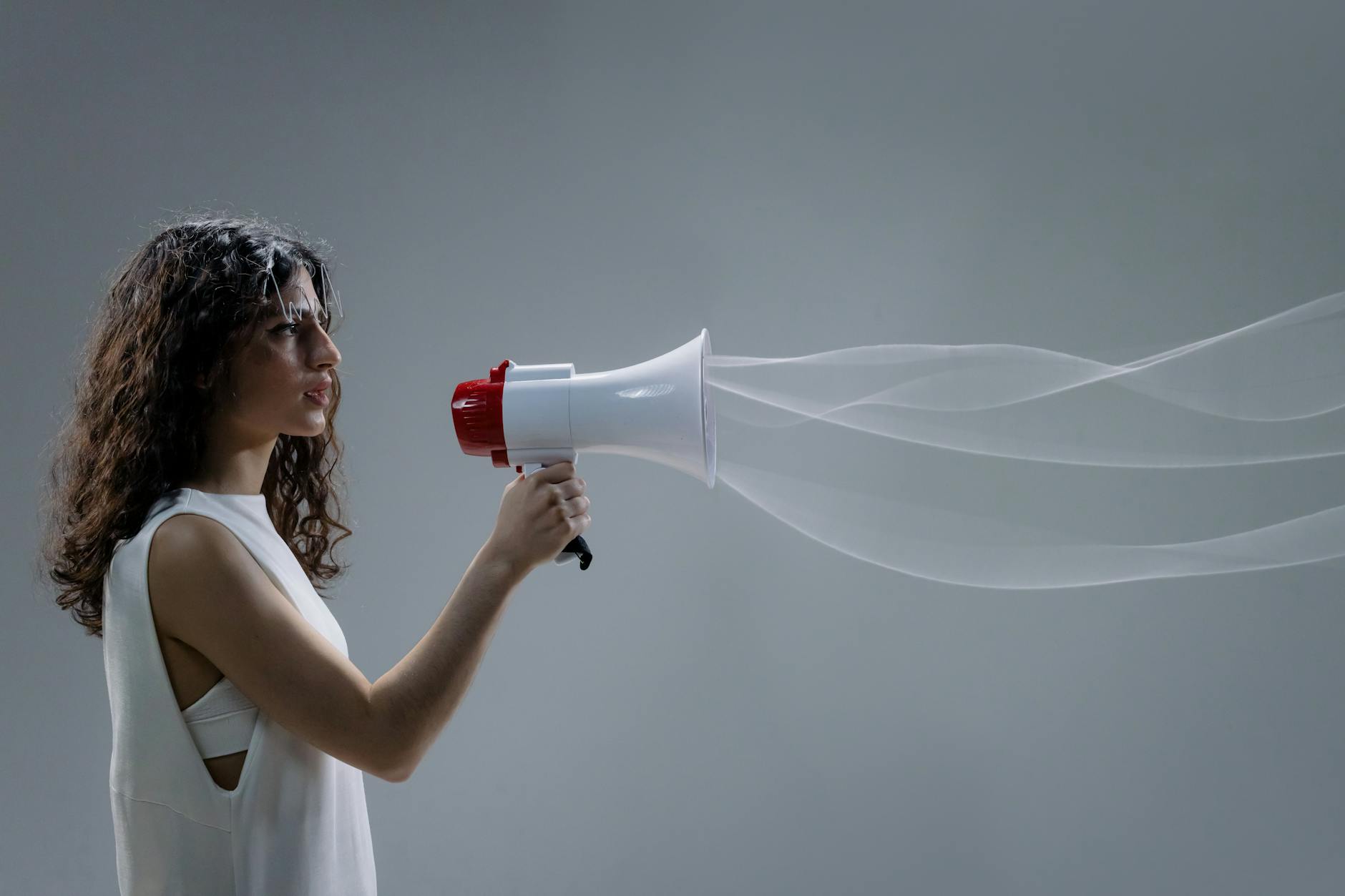 wavy haired woman holding a megaphone