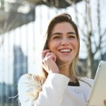 woman in white blazer holding tablet computer